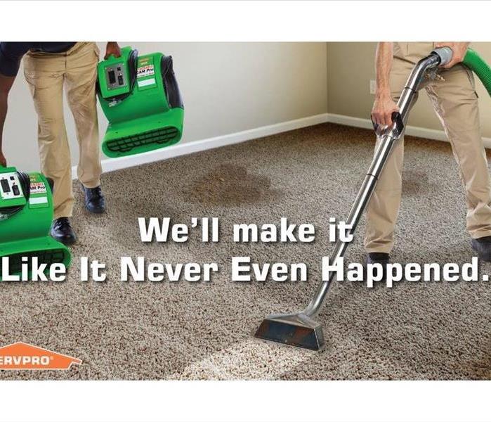 SERVPRO technician cleaning dirty carpet with a carpet cleaner. Second SERVPRO technician placing air movers. 